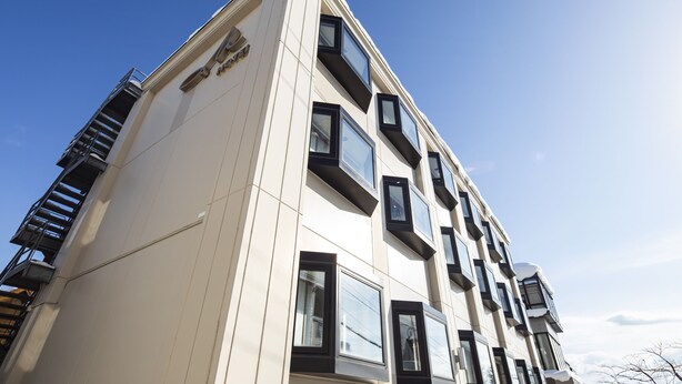 A modern building with a white facade, multiple windows, and a visible fire escape. - M Hotel (Kutchan)