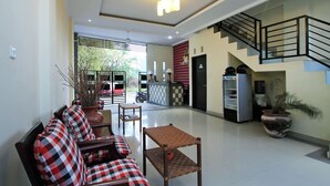 Una sala de estar moderna con un sofá, sillones, una mesa de centro y una escalera.