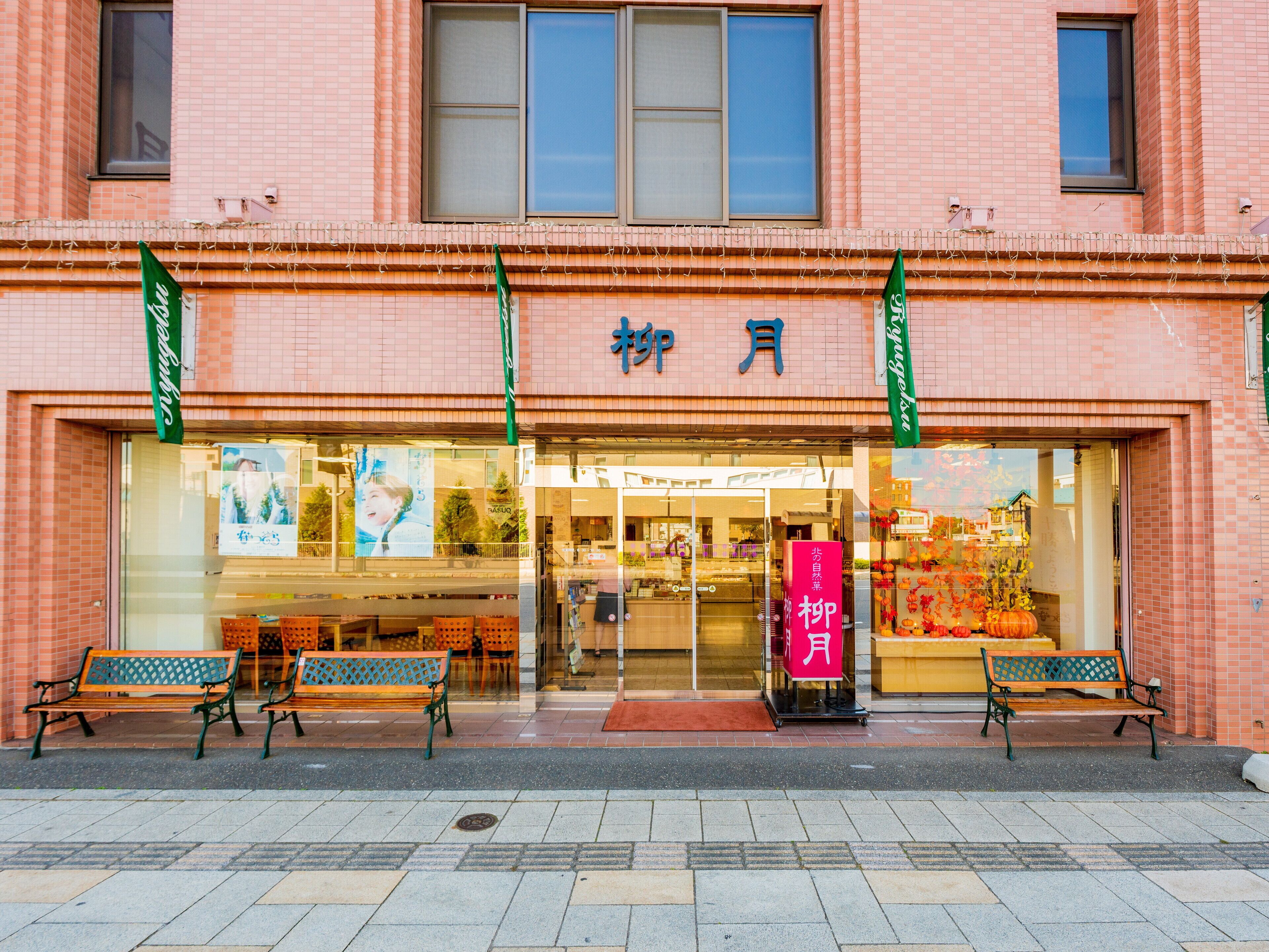 A building with a storefront, large windows, and a sign in a foreign language.