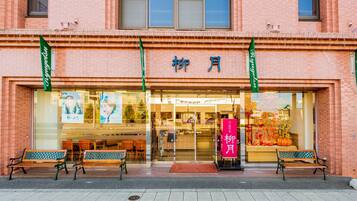 A building with a storefront, large windows, and a sign in a foreign language.