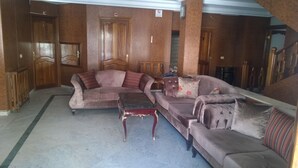 A spacious living area with a large sofa set, a coffee table, and a small side table. - Hôtel L´Excellence (Ariana)