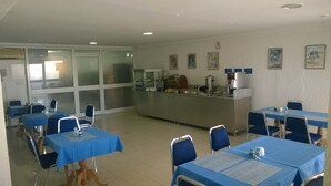 A dining area with tables and chairs, a buffet counter, and a refrigerator. - Hôtel L´Excellence (Ariana)