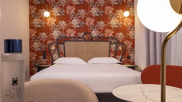 Une chambre d’hôtel avec un lit, une table ronde, une chaise et une table de chevet.
