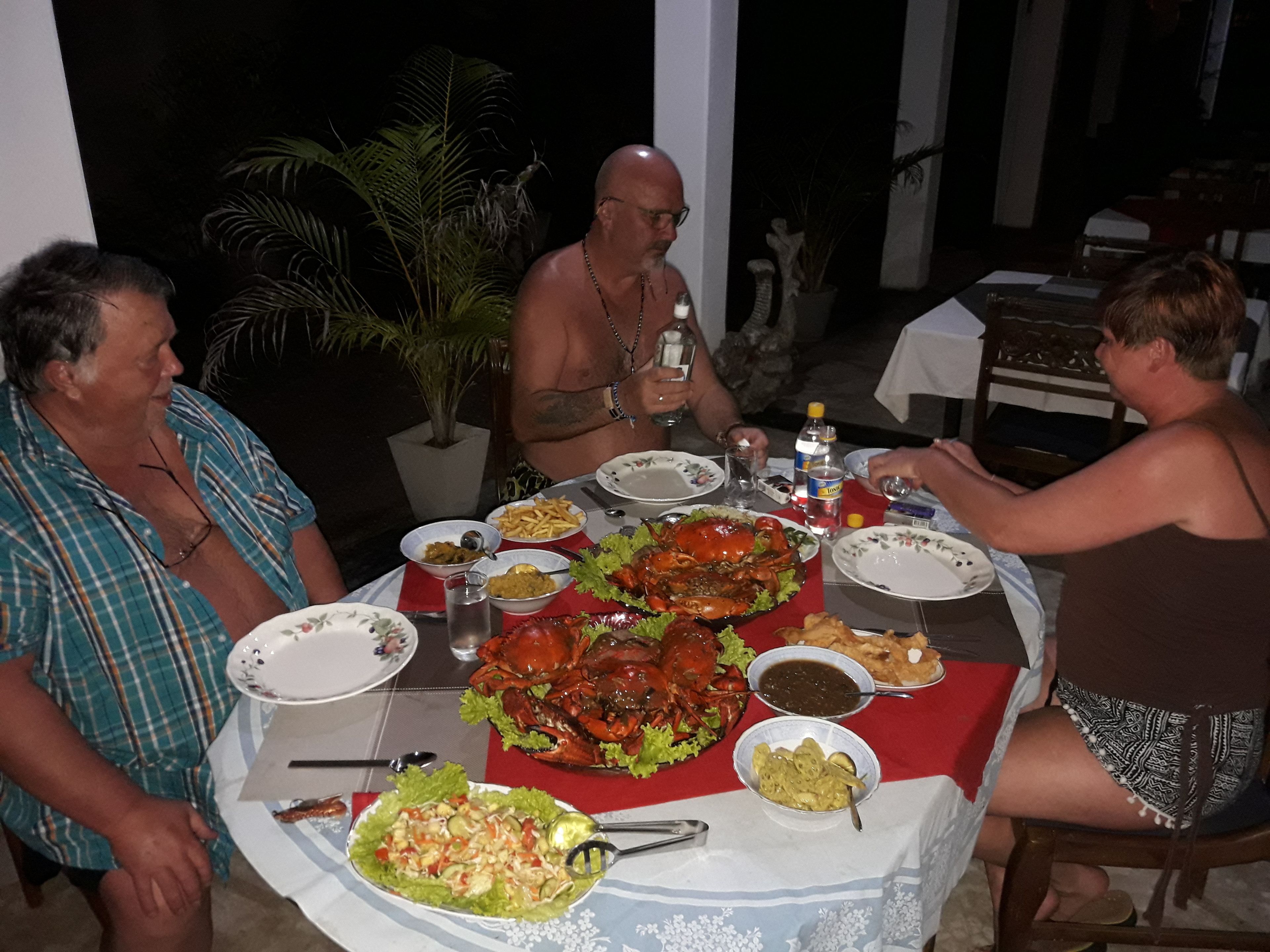 A dining table with various dishes, including a large crab, salad, and other food items.