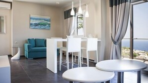 Een moderne hotelkamer met een zithoek, een sofa en een groot raam met gordijnen.