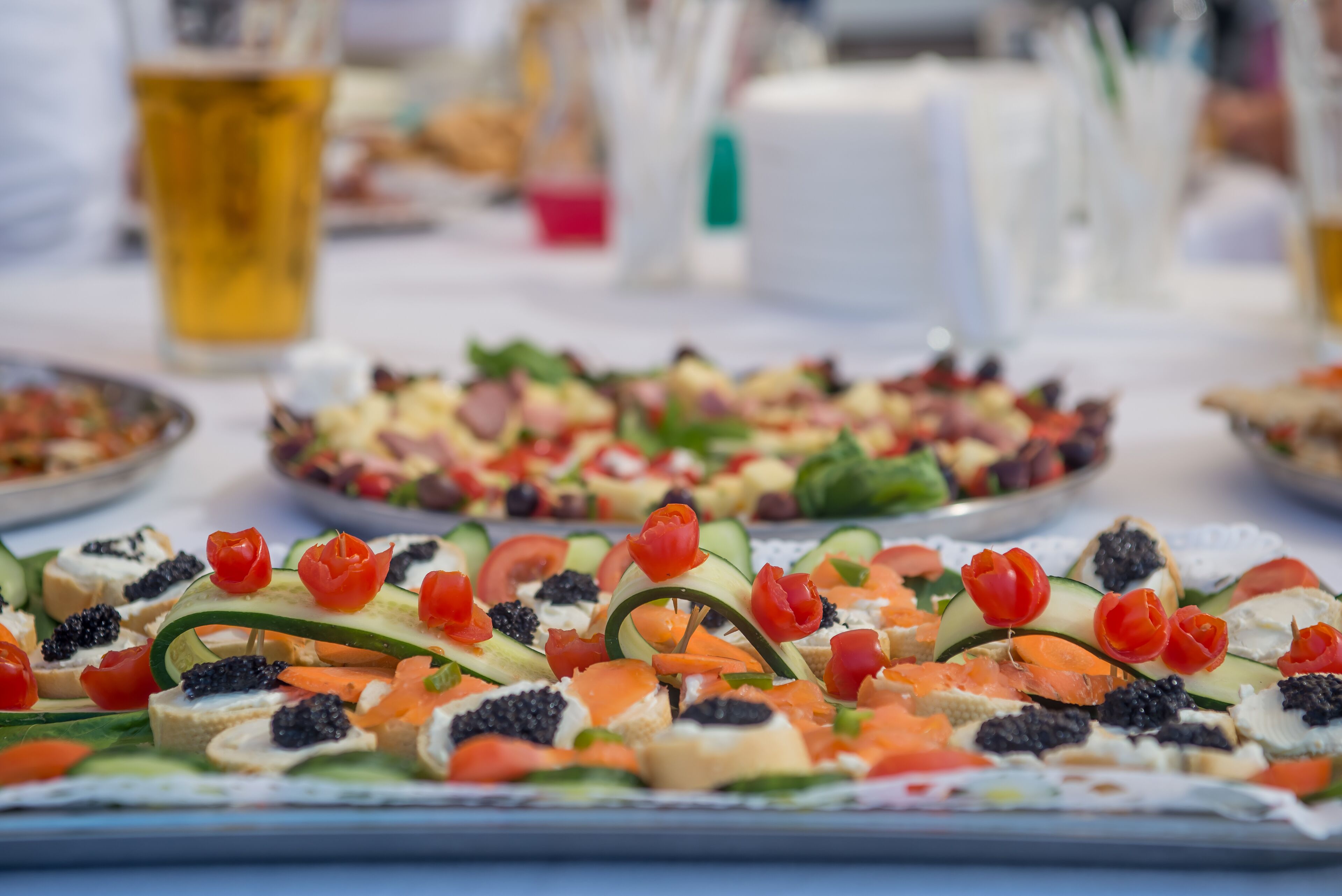 Variedad de aperitivos sobre una mesa, entre ellos vegetales cortados, queso y caviar.