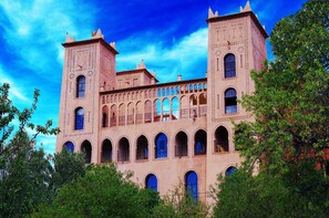 A large, historic building with multiple arched windows and two prominent towers.