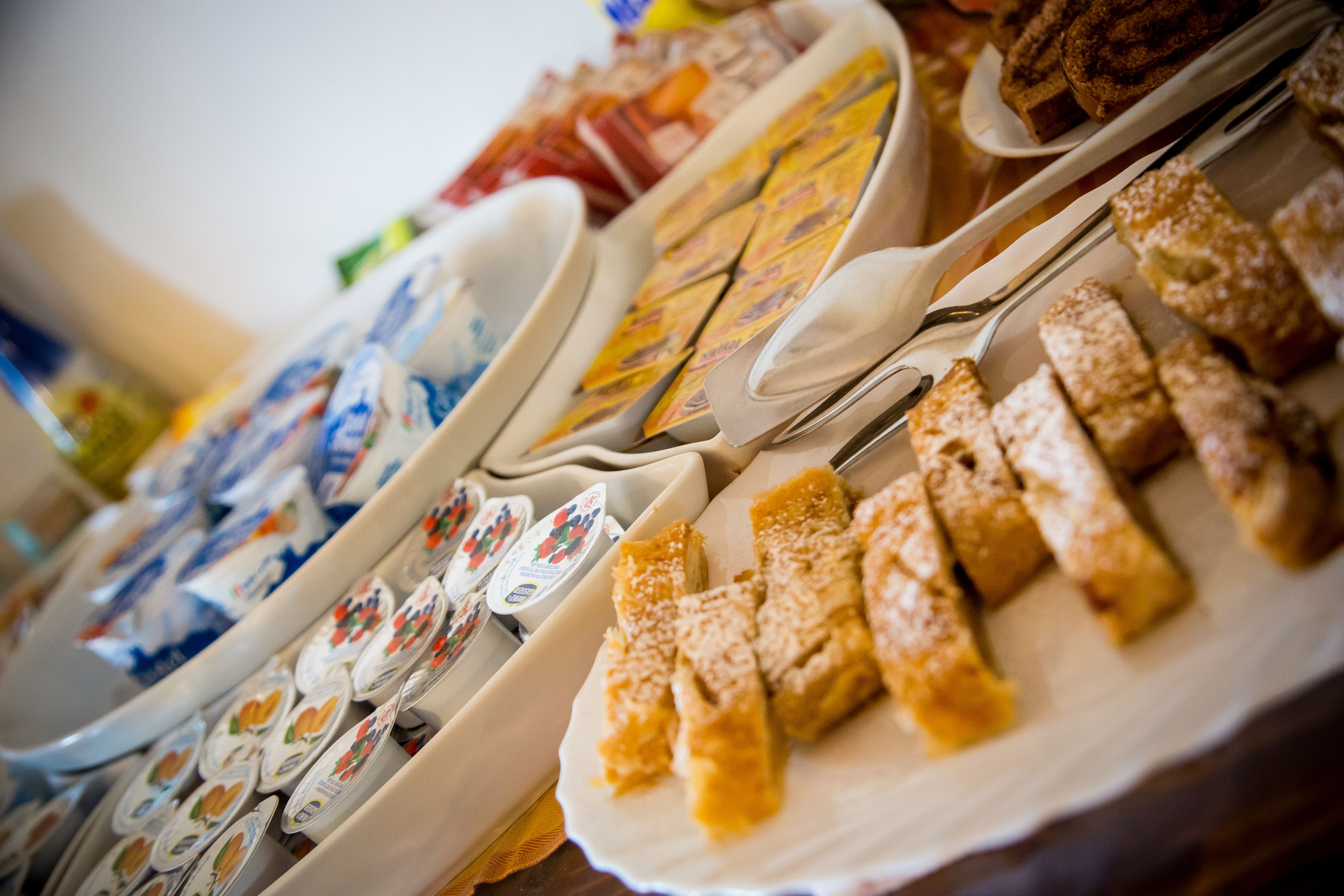 Buffet-pöytä, jossa on tarjolla monenlaista ruokaa ja ruokailuvälineitä.