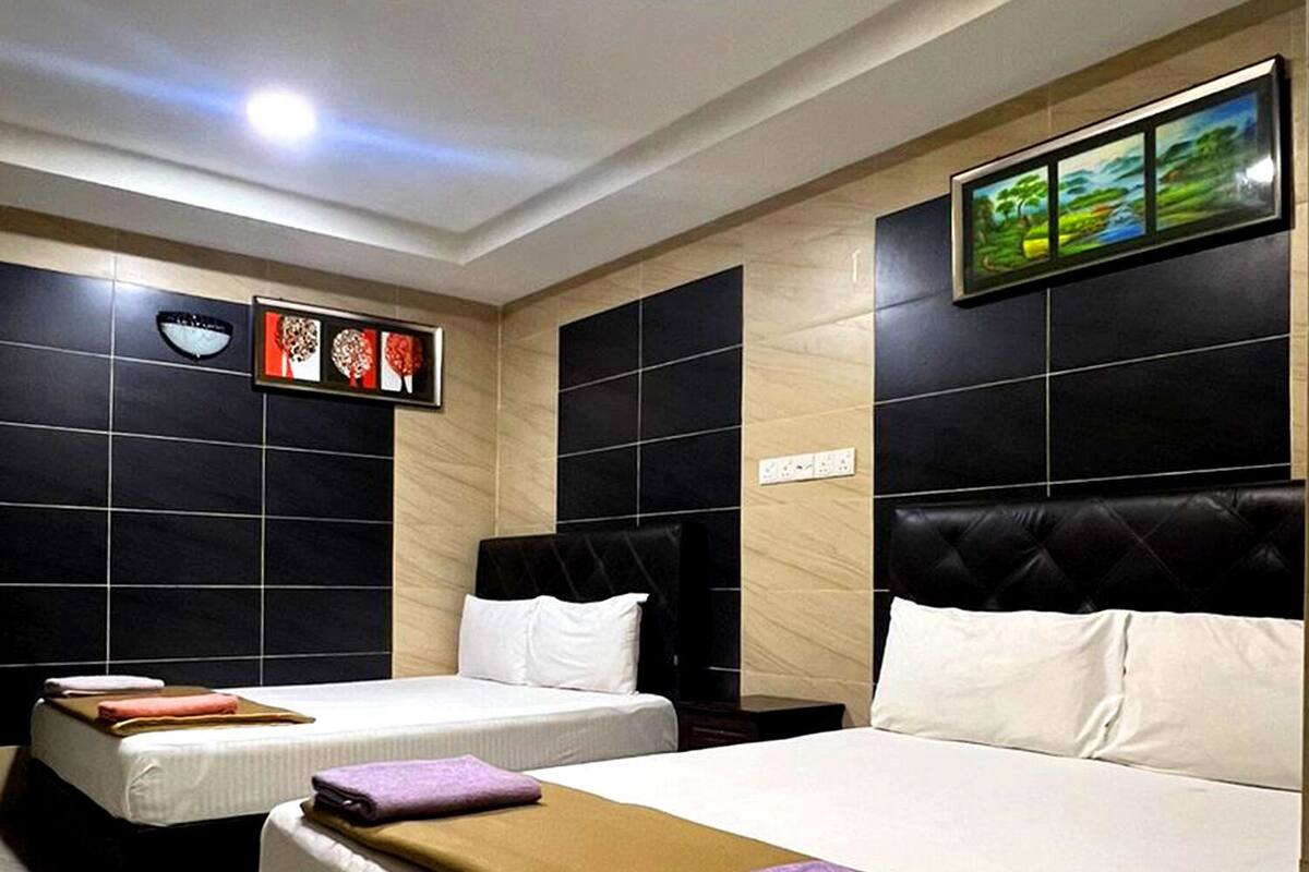 Habitación de hotel con dos camas, un ventanal grande y un cuadro en la pared.
