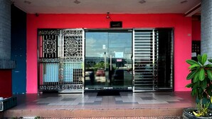 L’entrée d’un hôtel avec une porte en verre, des portails en métal et un sol recouvert de carreaux.