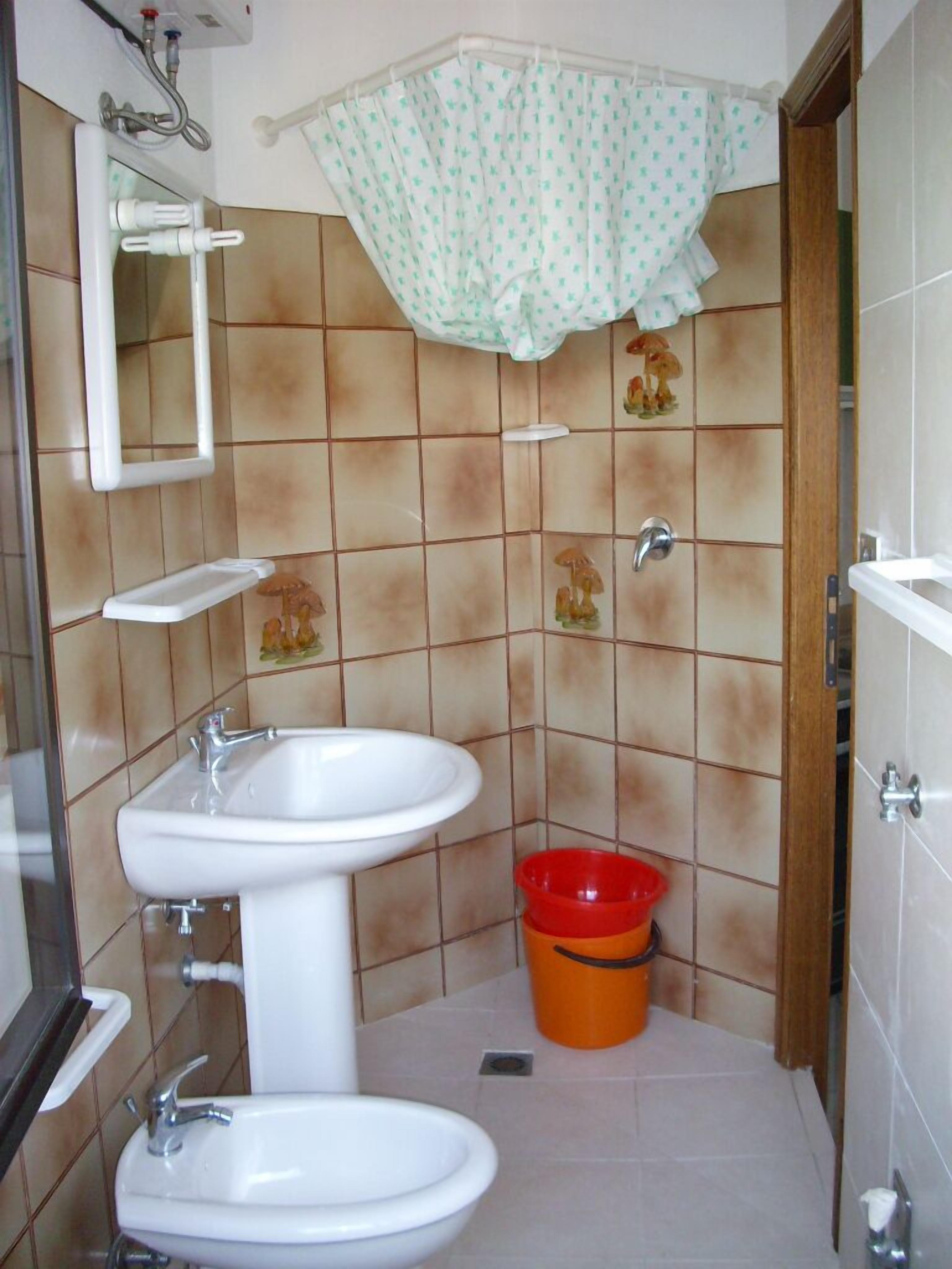 A bathroom with a sink, toilet, and shower area.