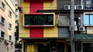 A multi-story hotel with a prominent red and yellow facade, large windows, and a visible entrance. - Shah Alam Business Hotel (Shah Alam)