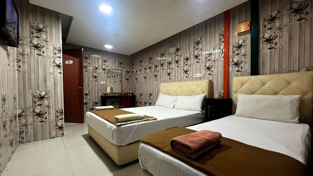 A hotel room with two beds, a desk, and a chair. - Shah Alam Business Hotel (Shah Alam)