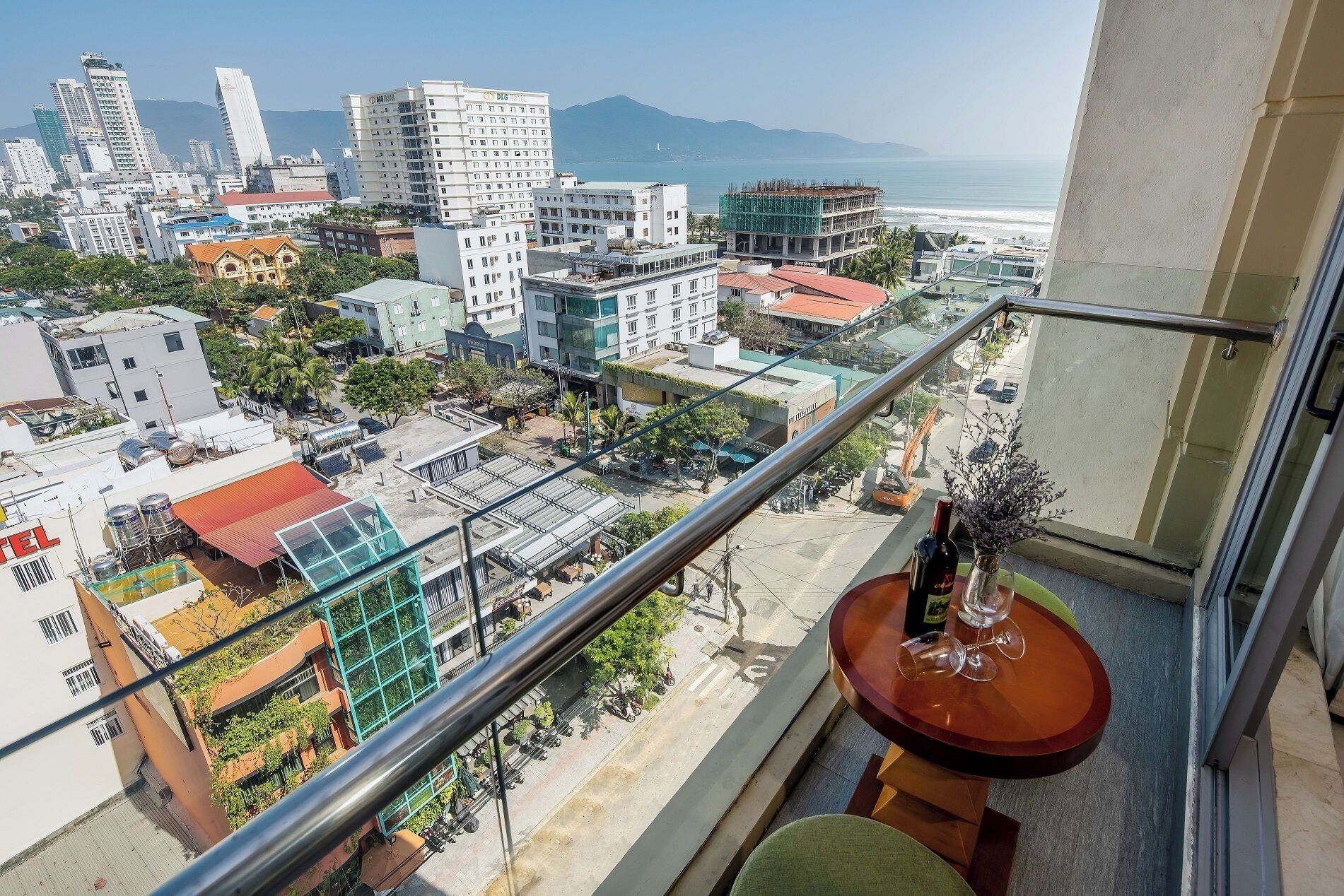 A balcony with a view of a cityscape, including buildings and a beach.