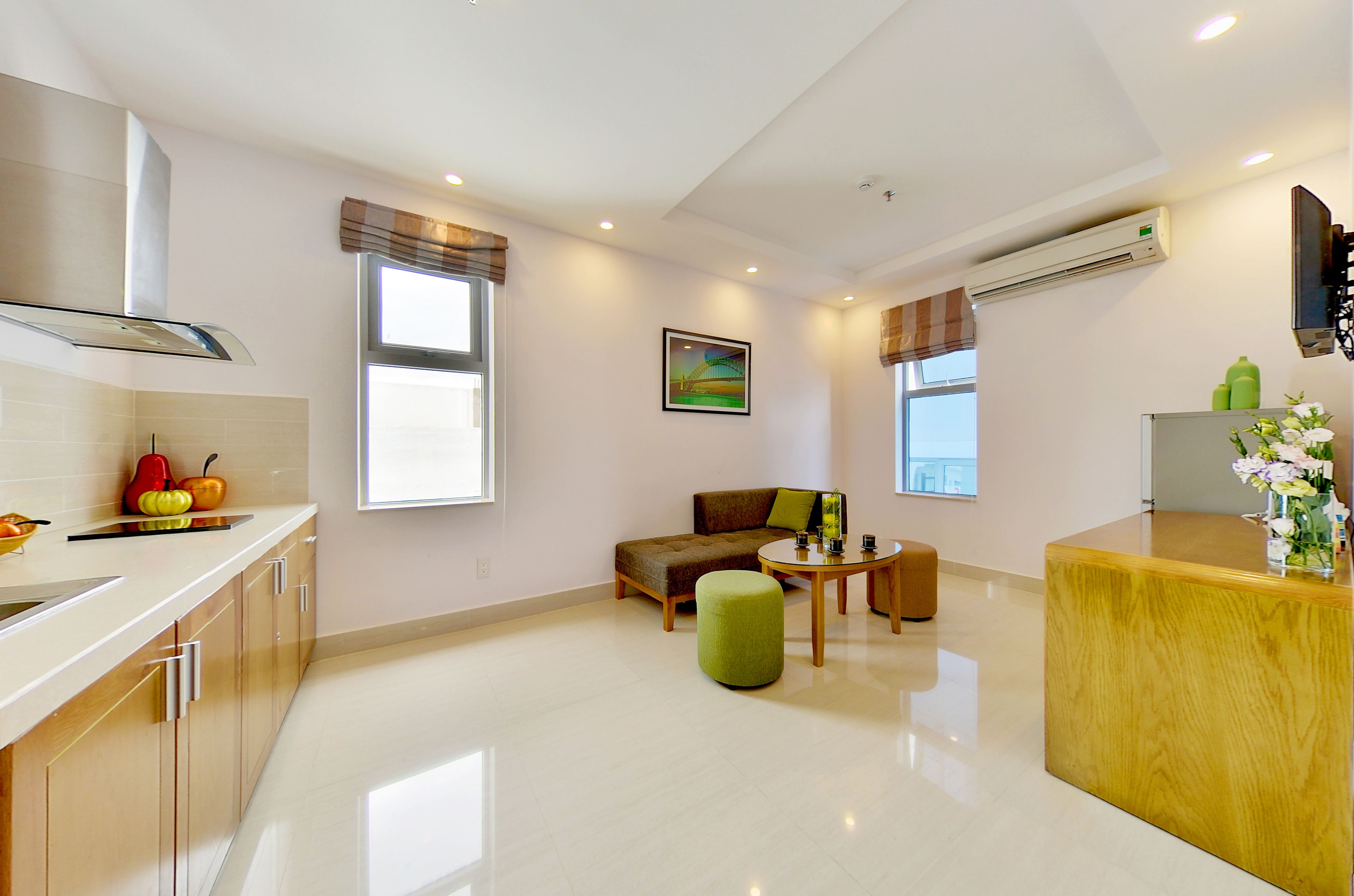 A modern kitchen with a dining area, a sofa, and a small table.