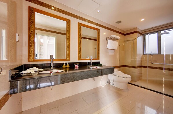 Un baño moderno con un espejo grande, un lavabo y un inodoro.