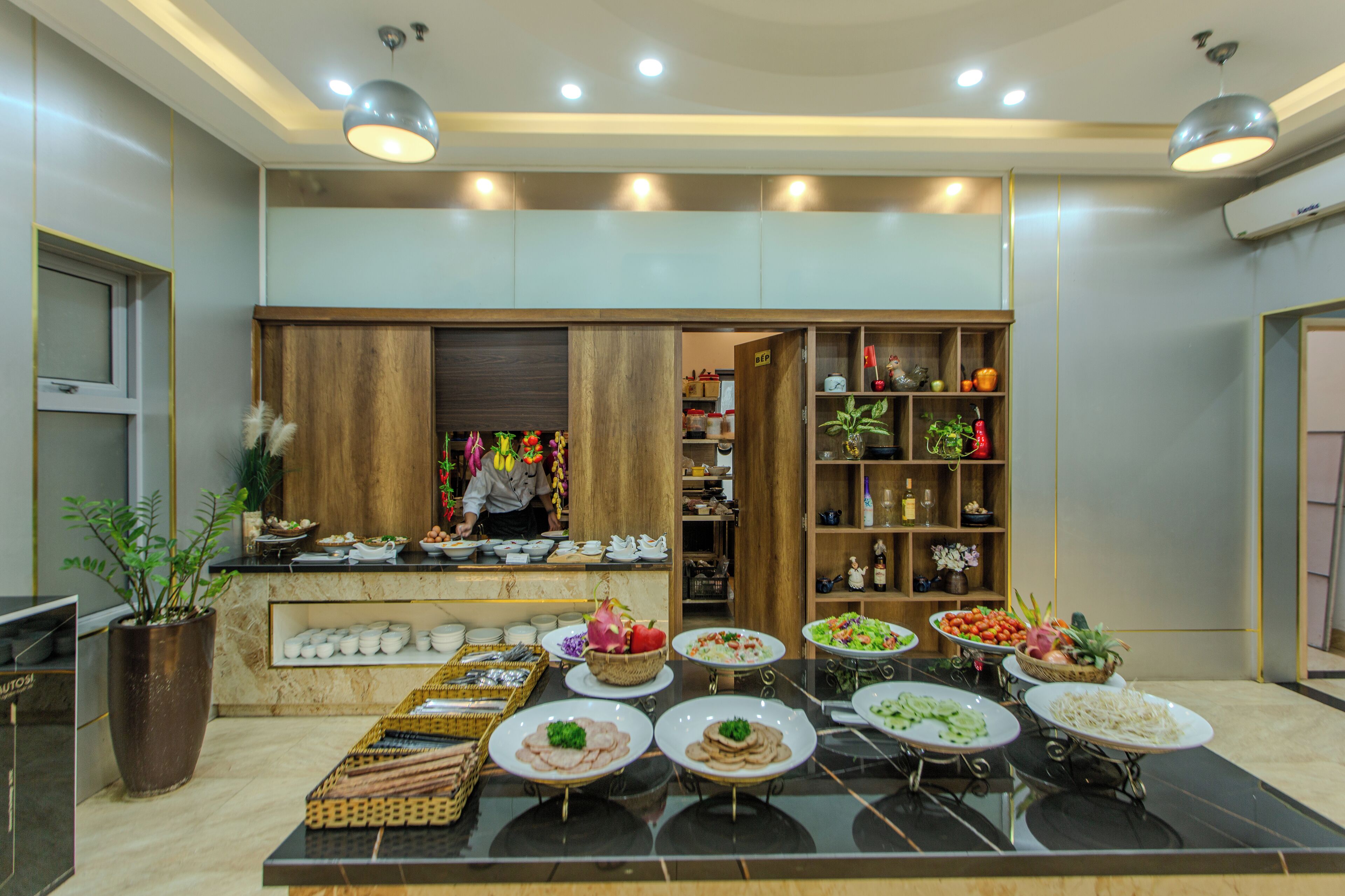 A buffet setup with various dishes and a chef preparing food.