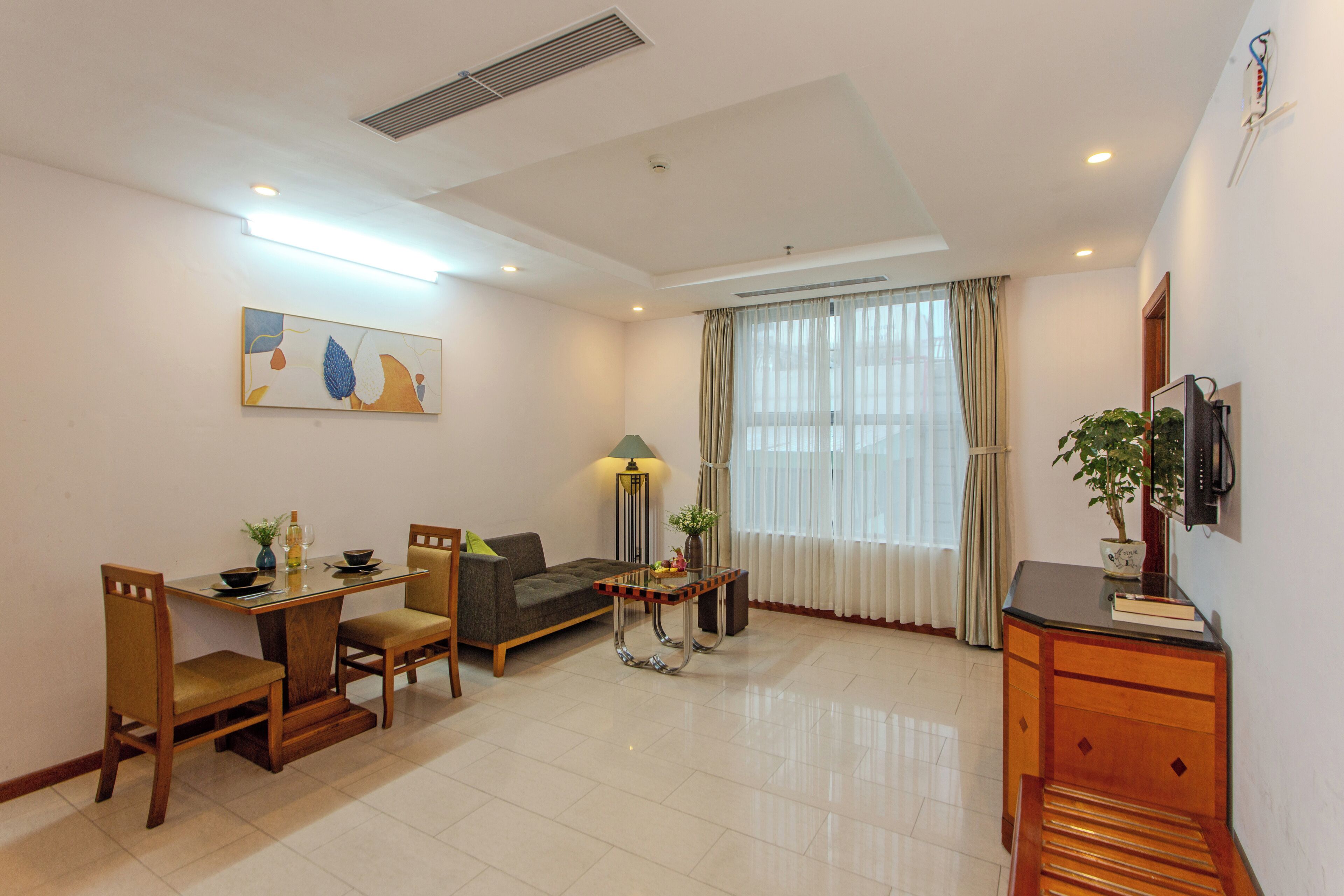 A modern living room with a dining table, sofa, and TV.