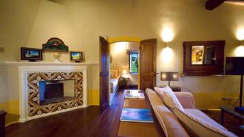 A cozy living room with a fireplace, a sofa, and a TV.