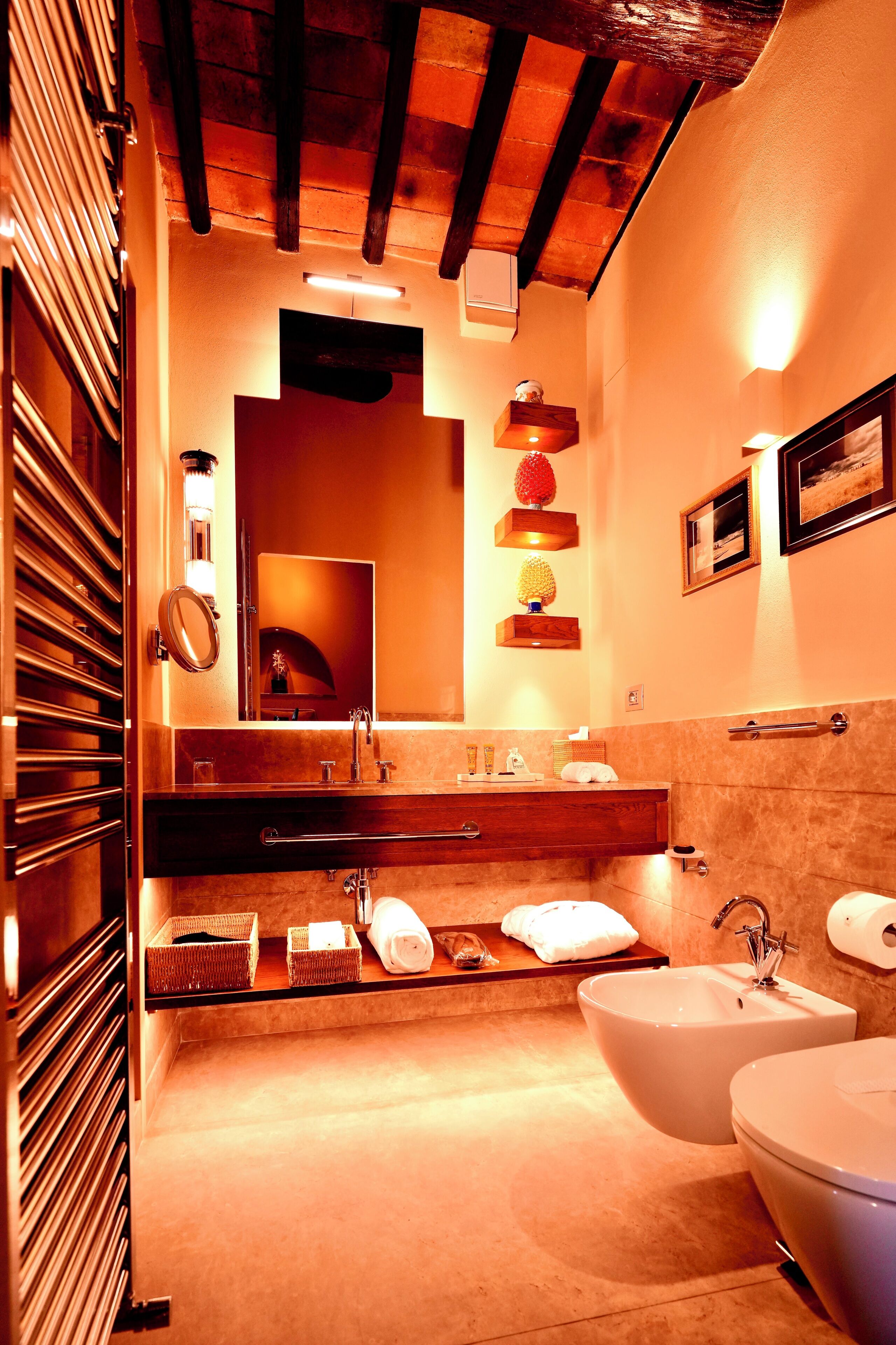 A modern bathroom with a wooden ceiling, a large mirror, a sink, and a toilet.