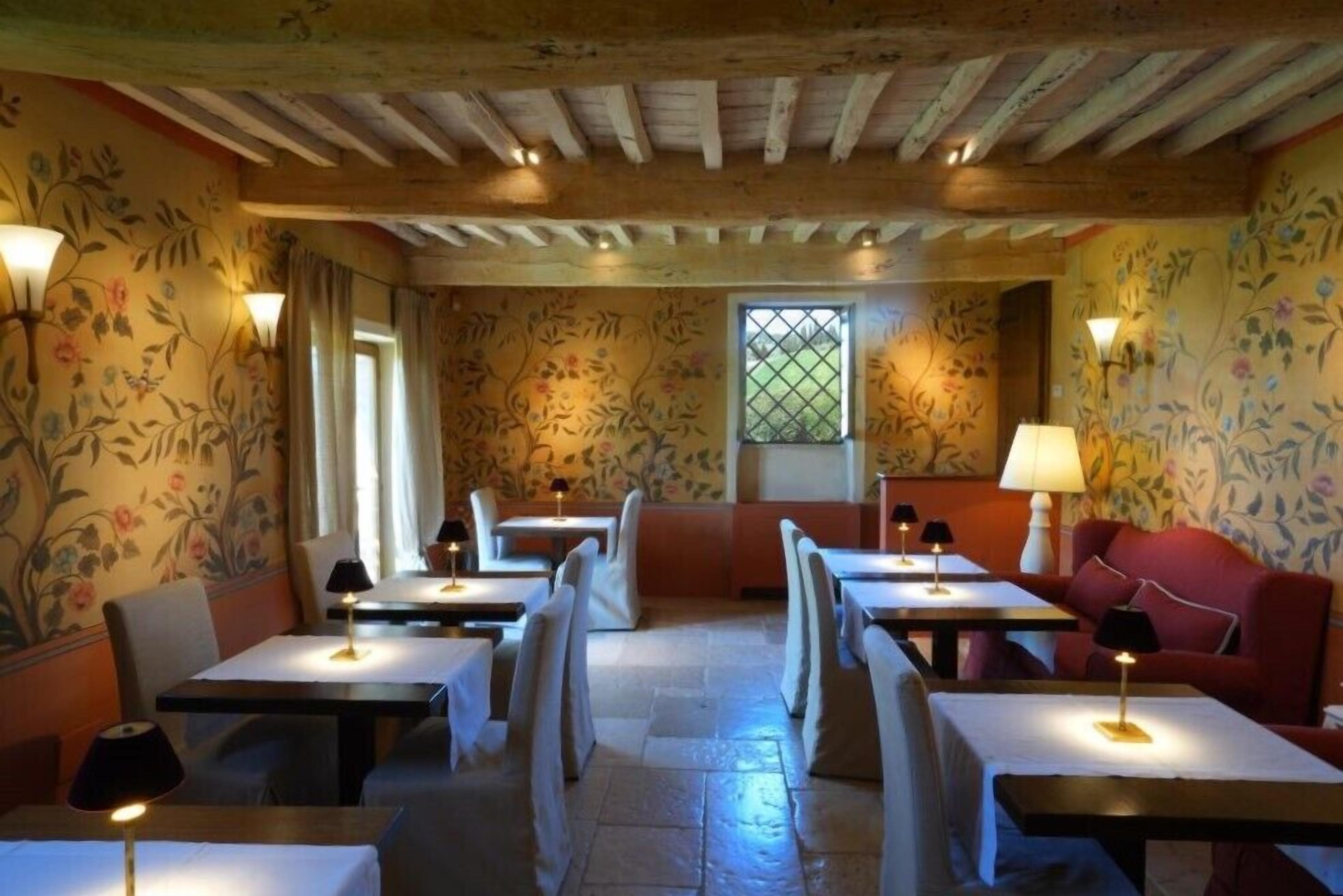 Un restaurant amb bigues de fusta, paper pintat amb motius florals i taules il·luminades amb làmpades.