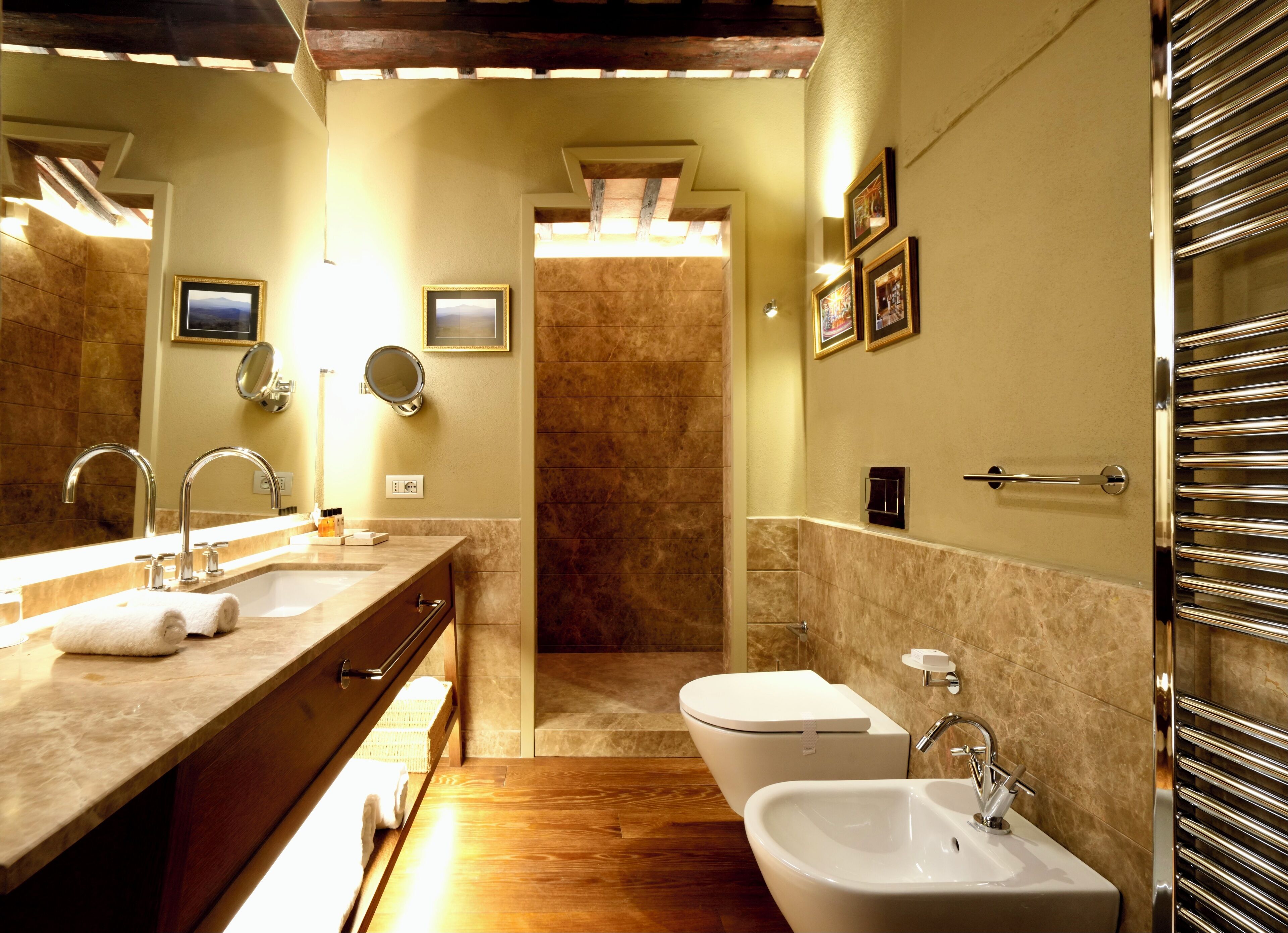 A modern bathroom with a double sink, a bidet, and a shower.