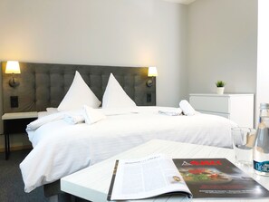 A neatly made bed with white linens, two bedside lamps, a small potted plant on a nightstand, and a magazine on a table. - Residence Aparthotel (Szczecin)