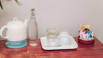 Ein Teeset mit Teekanne, Glasflasche, zwei kleinen Gläsern, einer Tablett mit Tasse und Löffel sowie einer Schale mit Teebeuteln.