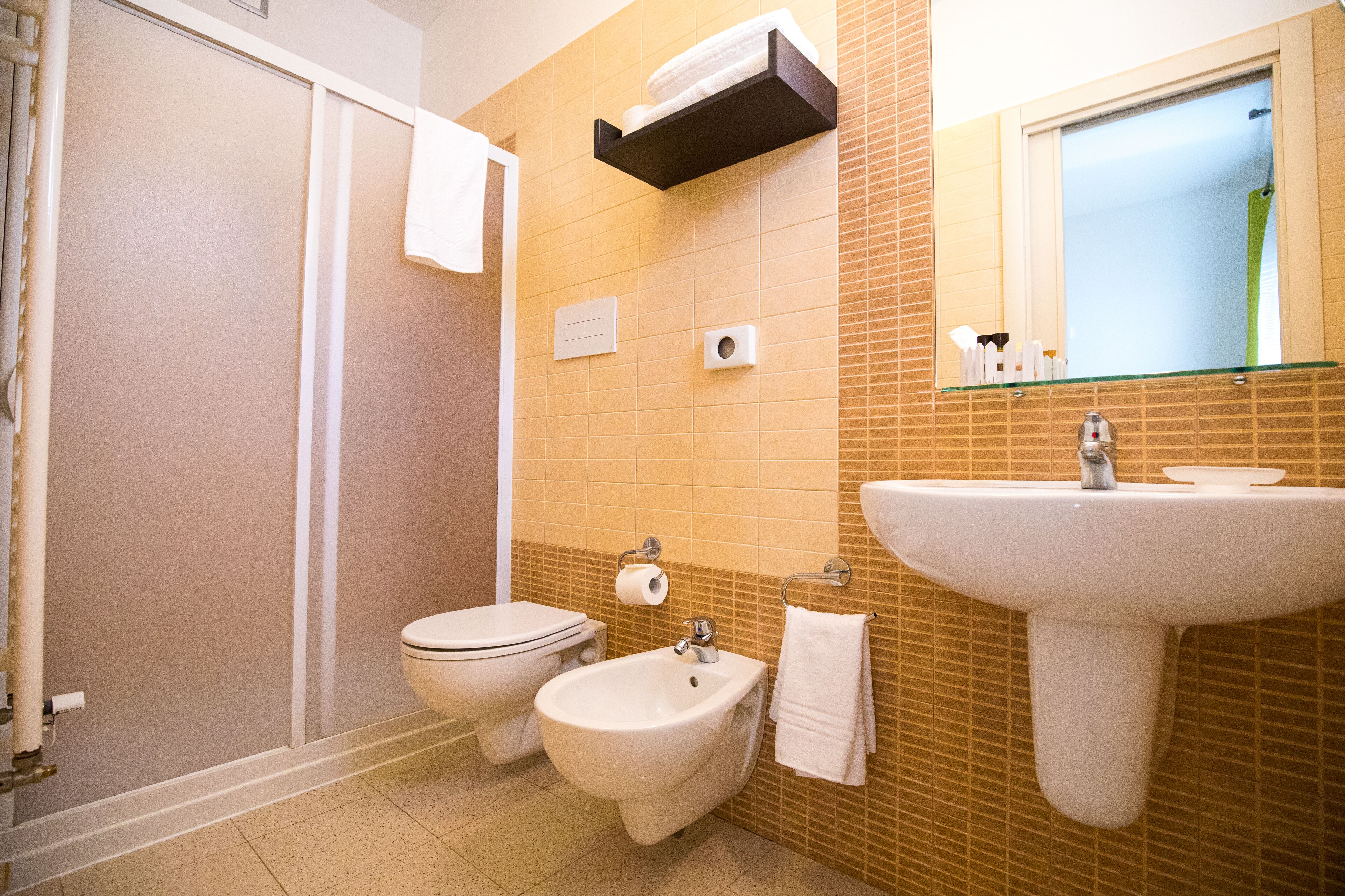 A bathroom with a toilet, bidet, and sink.