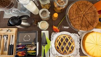 Ein Tisch mit verschiedenen Speisen, darunter ein Kuchen, eine Torte und Gläser mit Zutaten.