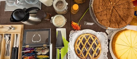 Uma mesa com diversos alimentos, incluindo torta, bolo e potes com ingredientes.