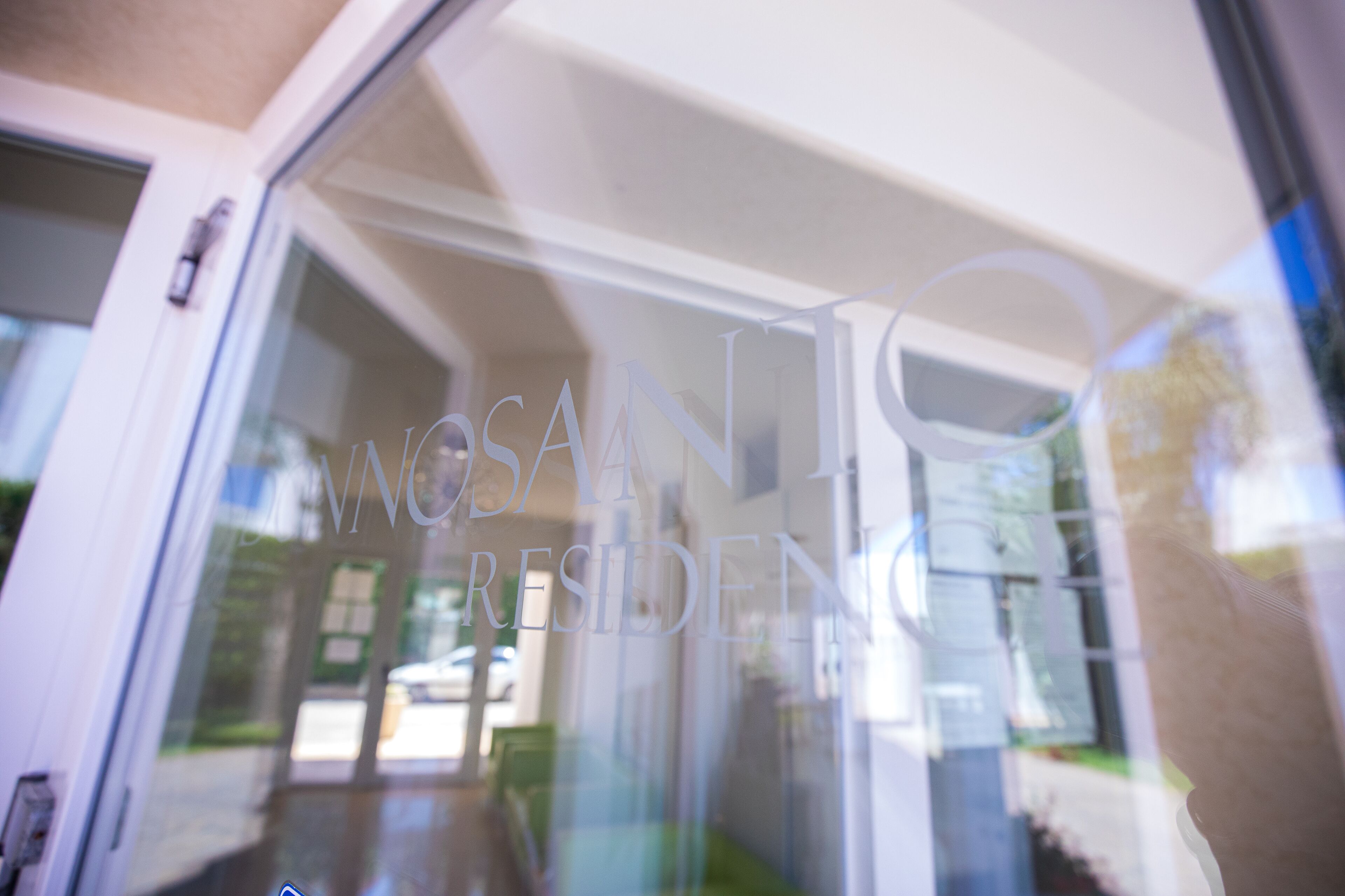 A glass door with the text "NOSANT RESIDENS" partially visible.