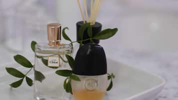 Dos botellas de perfume sobre una bandeja blanca con palitos de junco.