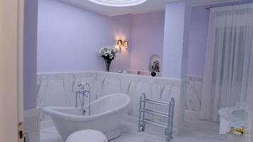 Un baño moderno con una bañera independiente, un tocador con espejo y una zona de ducha.