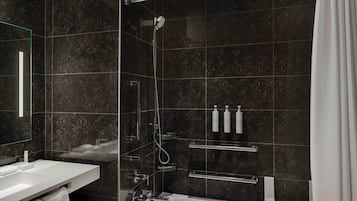 Une salle de bain moderne avec une douche à parois de verre, un lavabo blanc et un miroir.