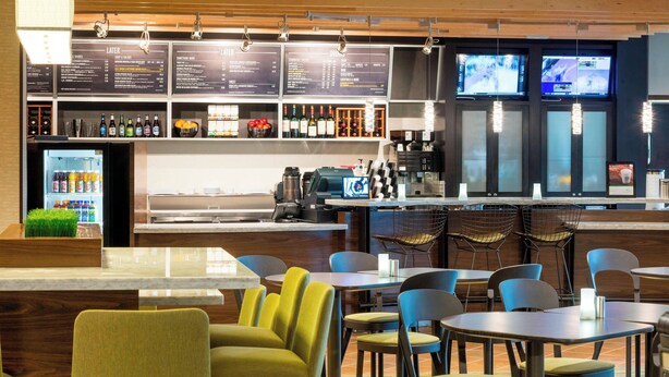 A modern restaurant with a bar area, seating, and a menu display.