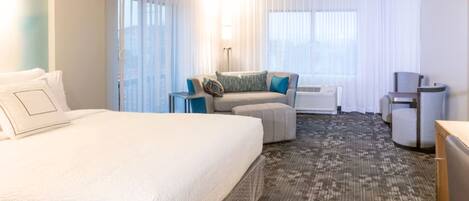 Een hotelkamer met een groot bed, een bank, een bureau en een stoel.