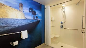 A bathroom with a shower, a toilet, and a towel rack.