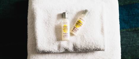 A white towel with two bottles of Verve Lavender body lotion on it.