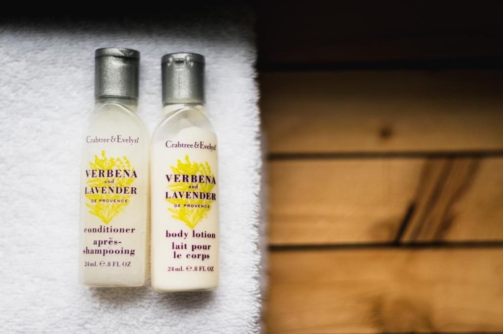 Two bottles of Crabtree & Evelyn perfume on a white towel.