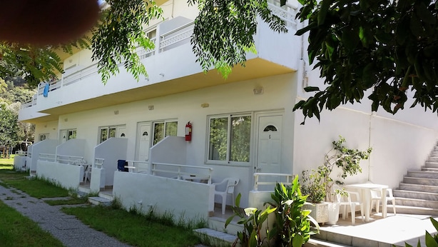 A white building with multiple balconies, a fire extinguisher, and outdoor seating. - Solemar Apartments (Rhodes)