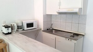 A compact kitchen with a microwave, toaster, and coffee maker on the countertop. - Solemar Apartments (Rhodes)