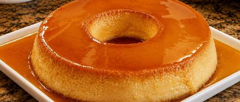 A single serving of flan on a white plate.