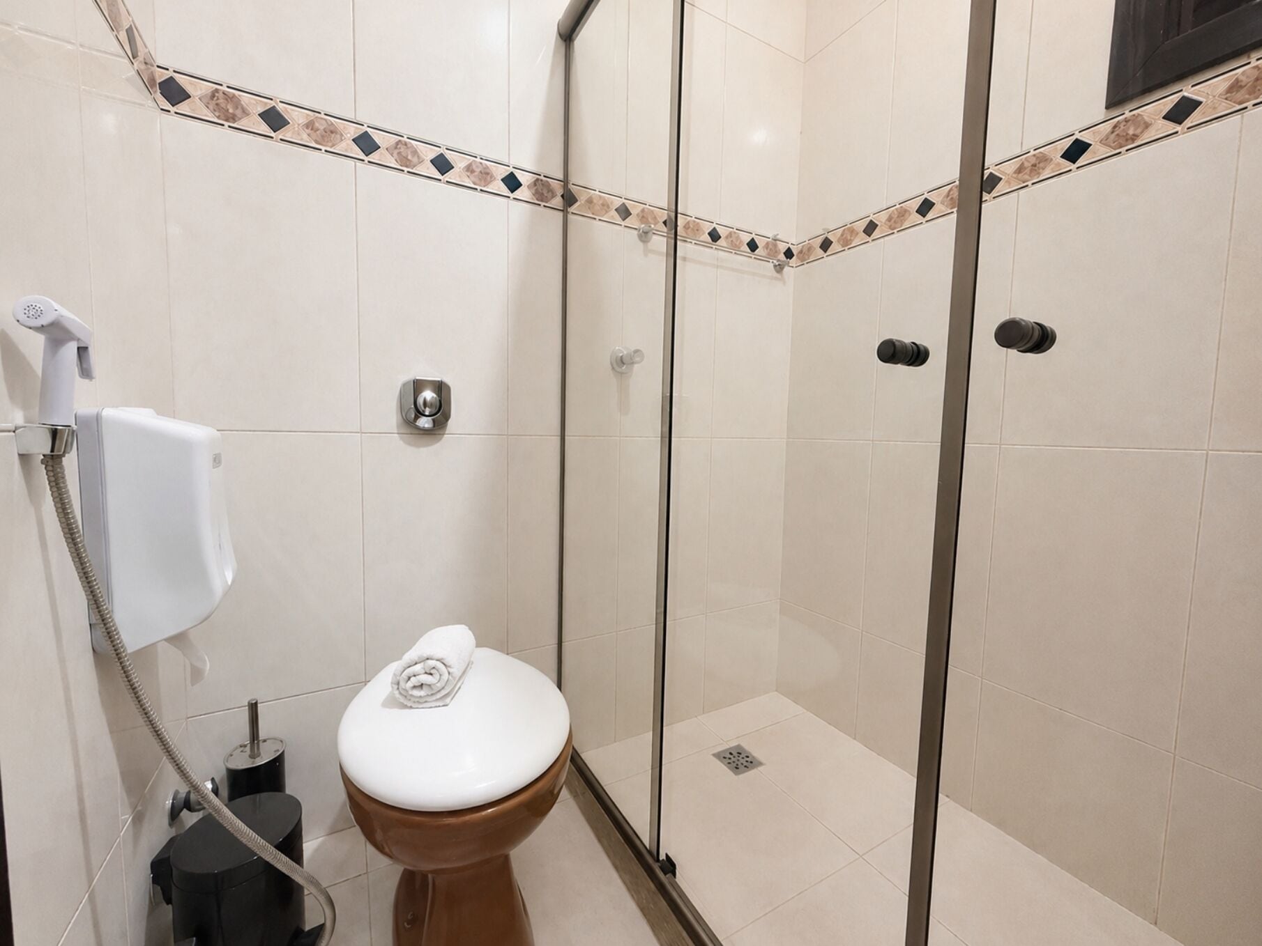 Un bagno con un water, uno spazio doccia e un portasciugamani.
