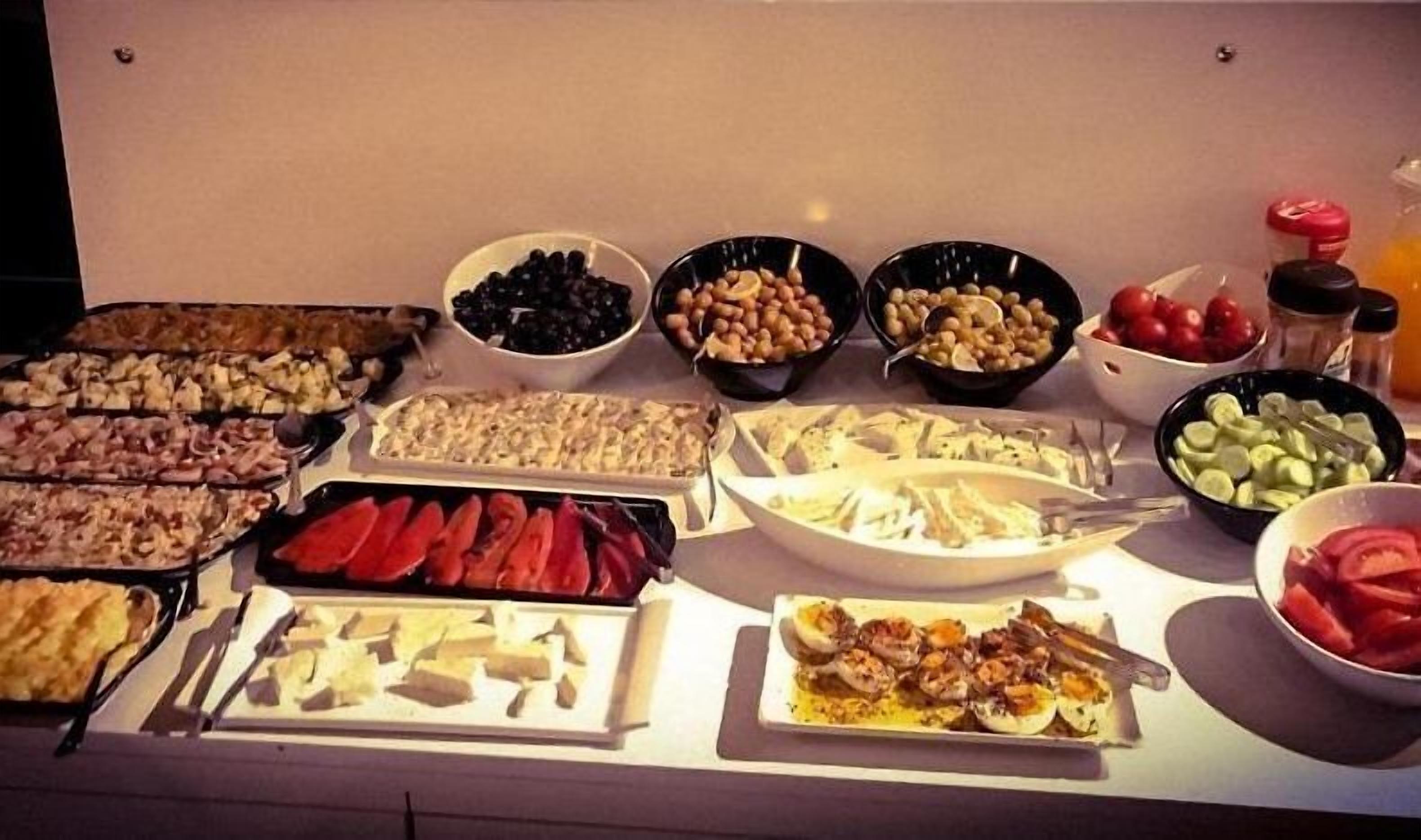 Un buffet proposant une variété de plats, notamment des viandes, des fromages et des légumes.