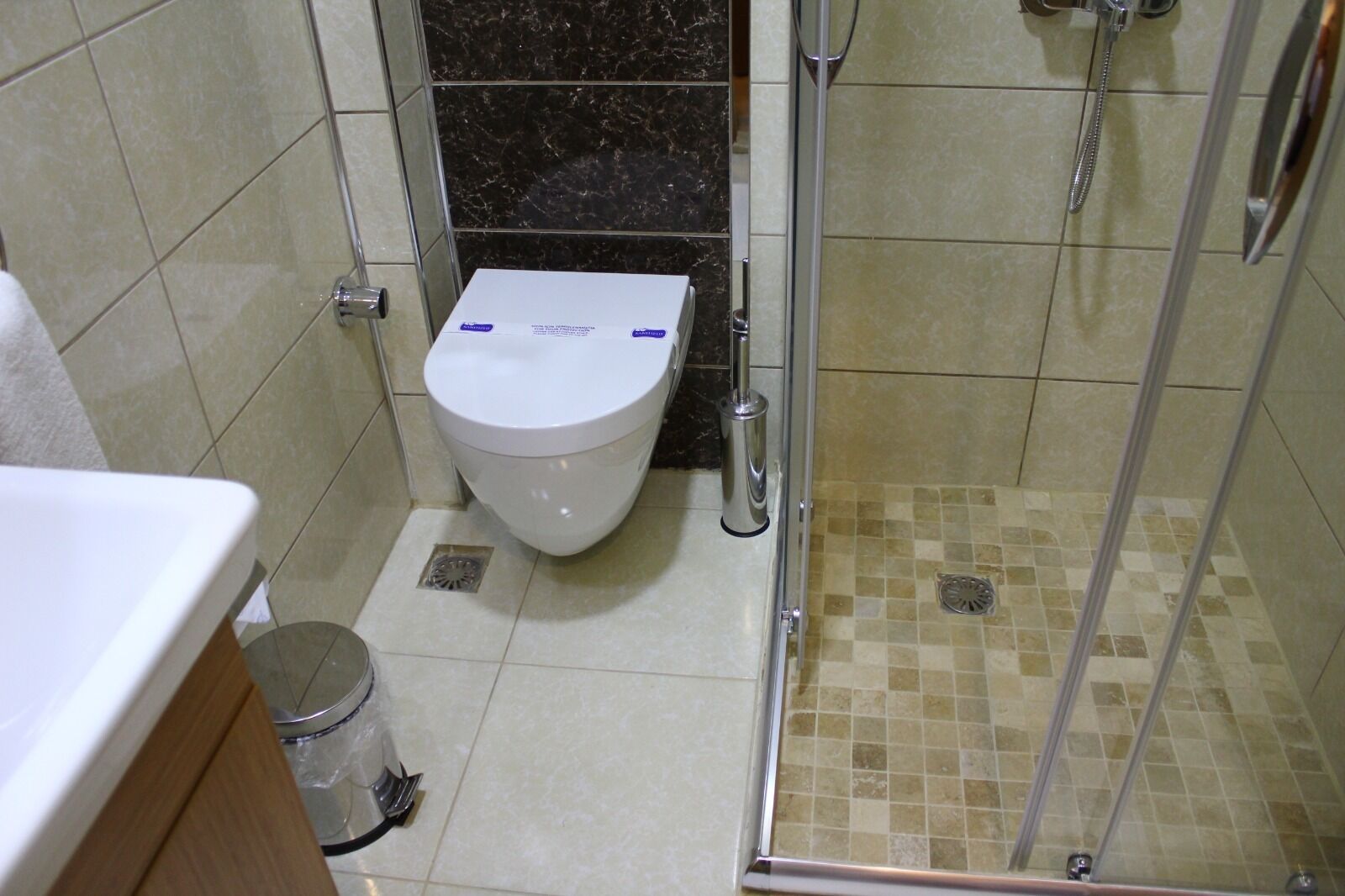 A bathroom with a toilet, a shower, and a sink.