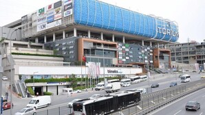 Un stade moderne, doté de plusieurs niveaux et orné de panneaux publicitaires.