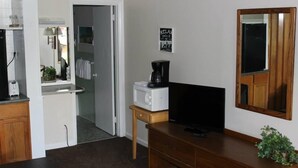 A compact living space with a kitchenette, a microwave, a coffee maker, a television, and a mirror. - Kentucky Lake Resort & RV Park (Gilbertsville)