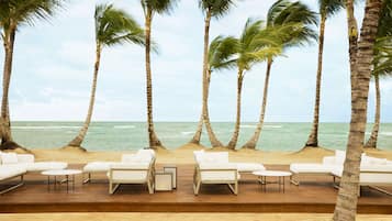 Aan het strand, wit zand, ligstoelen aan het strand, parasols