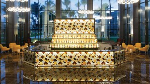 A lobby with a central bar area, large windows, and modern lighting fixtures. - Excellence Carmen Punta Cana - Adults Only All Inclusive (Punta Cana)